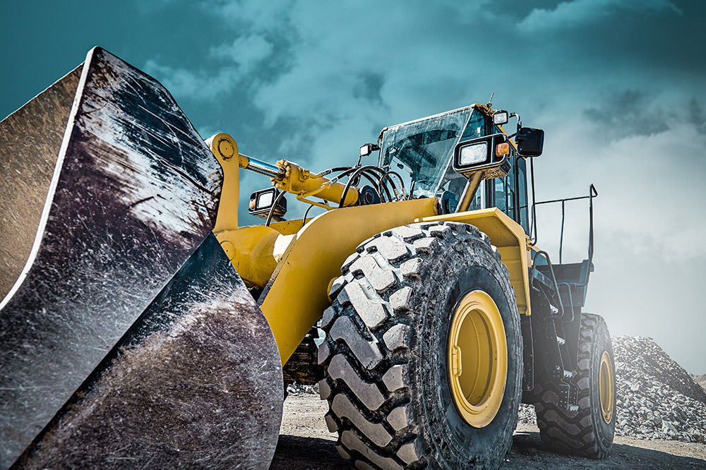 Front loader construction machine in front of cloudy sky