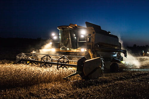 A plow machine plows through field at night