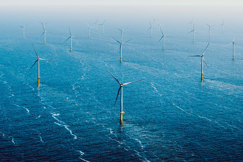 Around twenty wind turbines standing in the sea